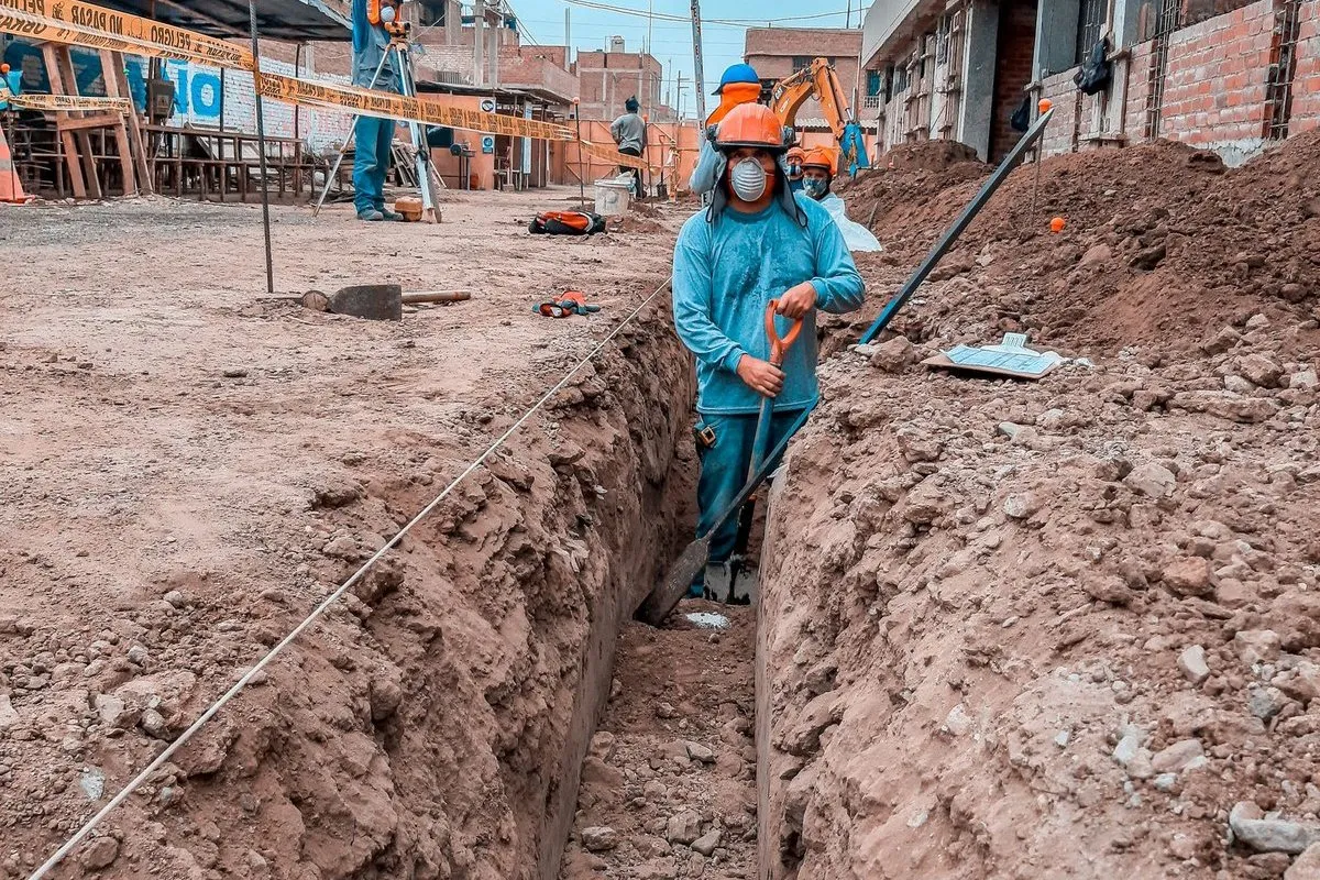 Worker excavating and leveling ground for a paver patio base